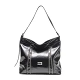 Cartera de hombro tipo hobo confeccionada en cuero negro con acabado brillante. Presenta dos cierres verticales decorativos en el frente, correa ajustable y placa metálica con logo en la parte central.