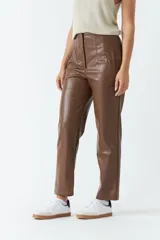 Pantalón de cuero sintético marrón, de tiro alto y corte recto, con pinzas y tablas en la parte delantera.