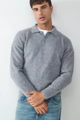 Sweater de punto suave color gris, con cuello polo y cierre frontal de tres botones. Confeccionado en un tejido abrigado.