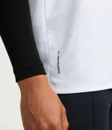 Musculosa deportiva de corte regular, color blanco, con cuello redondo y una tira reflectante horizontal centrada en el pecho.