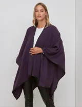 Ruana de tejido soft color violeta oscuro, con bordes terminados en vivo de cuero sintético negro.