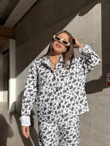 Camisa de denim con estampado de manchas de vaca, corte recto y cierre frontal con botones.