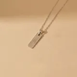 Collar de cadena fina con dije rectangular de superficie texturizada, elaborado en plata 925.