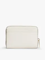 Billetera compacta Tommy Hilfiger de color blanco con acabado texturizado y cierre de cremallera perimetral. Cuenta con logo metálico dorado en relieve en la parte frontal.