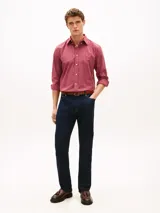 Camisa de corte regular de Tommy Hilfiger, confeccionada en popelín de puro algodón con acabado aterciopelado y diseño de cuadros en tonos rojos y blancos. Presenta cuello clásico abotonado, mangas largas con puños redondeados y el logo bordado en el pecho.