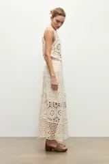 Falda midi beige de tejido crochet con diseño de motivos geométricos perforados.