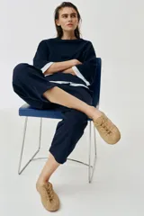 Zapato tipo blucher de estilo deportivo confeccionado en piel, con cierre mediante cordones, tirador trasero y detalle de pespuntes en el cuerpo. Presenta punta redonda y suela plana.