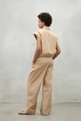 Pantalon de corte relajado y tiro alto, confeccionado en algodon, con pliegues frontales y bolsillos laterales.