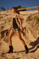 Botas cortas de gamuza color marrón, con taco cuadrado y punta ligeramente elevada. Presentan un detalle de trenzado decorativo en la parte superior de la caña.