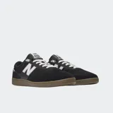 Championes urbanos New Balance modelo 508, color negro con detalles en gris y blanco, confeccionados en gamuza y malla, con logo "N" característico en los laterales y entresuela marrón.