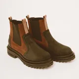 Botas estilo Chelsea de cuero color marrón, con paneles elásticos laterales negros, presillas traseras y suela chunky de goma negra con plataforma dentada.