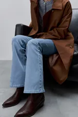 Jean flare de tiro medio, color celeste, con calce al cuerpo hasta la rodilla y pierna levemente acampanada.