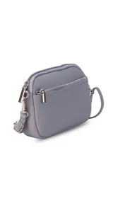 Bandolera pequeña de diseño rectangular en color beige, confeccionada en cuero sintético. Presenta una correa larga ajustable del mismo material y cierre superior con cremallera. Incluye el logo de la marca grabado en la parte frontal.