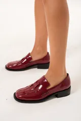 Mocasín de cuero charol color cereza con diseño enrejillado en la capellada, horma cuadrada, plataforma delantera y taco bajo.