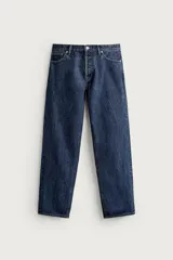 Jeans regular fit de tiro medio, confeccionados en denim de algodón azul oscuro con efecto lavado. Presenta diseño clásico de cinco bolsillos, pierna recta y cierre frontal con cremallera y botón.