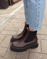Botas tipo Chelsea de cuero color marrón con paneles elásticos laterales negros y suela track de goma negra con plataforma.