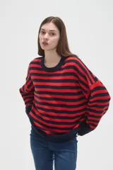 Sweater de tejido de punto con diseño de rayas horizontales en color rojo y azul marino, cuello redondo a la base y mangas largas con corte holgado.