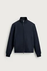 Buzo azul marino de corte regular fit, confeccionado en tejido de algodón compacto y pesado con interior de rizo afelpado. Cuenta con cuello alto, manga larga, bolsillos frontales de vivo, acabados en rib y cierre frontal con cremallera de doble dirección.