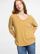 Remera de manga larga color mostaza con escote en V y bolsillo en el pecho.