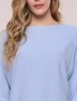 Buzo tejido liviano de calce holgado color celeste, con escote bote y mangas tipo dolman.
