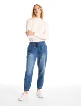 Pantalón tipo jogger de denim azul con efecto lavado. Presenta cintura elástica con cordón ajustable, bolsillos laterales y traseros, y puños elásticos en los tobillos.