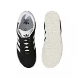 Championes urbanos Adidas modelo Gazelle, color negro con las icónicas tres tiras laterales y refuerzo en el talón en color blanco. Presenta el nombre del modelo en letras doradas en el lateral y suela de goma texturizada en color crema.