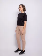 Pantalón tipo babucha de corte deportivo, color beige, con cintura elástica ajustable mediante cordón, puños en los tobillos y bolsillos frontales.