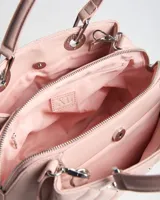 Cartera de símil cuero color rosa, con diseño matelassé y tachas metálicas. Cuenta con doble asa de mano, correa bandolera regulable y desmontable, herrajes plateados y logo XL metálico en el frente.