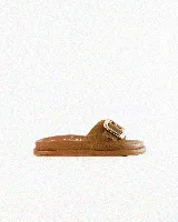 Sandalias de cuero color negro, de diseño plano con una tira ancha en el empeine y una hebilla metálica dorada grande como detalle.
