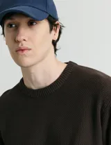 Sweater de punto con escote redondo, confeccionado en algodón con textura de punto fantasía en cuerpo y mangas, y terminaciones en punto canalé en cuello y puños.