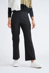 Pantalón de vestir negro con corte trompeta, tiro medio y cintura con pasacintos.