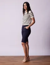 Bermuda blanca de gabardina elastizada marca Zac & Rachel. Tiene pretina ancha elastizada, bolsillos delanteros y traseros, y ruedo con dobladillo.