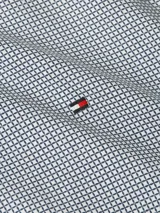 Camisa de manga larga Tommy Hilfiger para hombre con micro estampado de puntos azules. Cuenta con cuello inglés, cierre frontal con botones y logo de la marca bordado en el pecho.