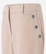 Pantalón slim color beige, confeccionado en crepé, con cierre delantero en la cintura y detalles de ojales en los bolsillos.
