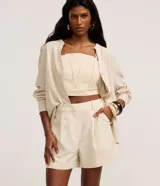 Short femenino color marrón oscuro, con trabillas en la cintura, pliegues frontales y solapa trasera.