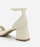 Sandalias negras de cuero sintético, con punta cuadrada, tira fina sobre los dedos, pulsera con hebilla al tobillo y tacón geométrico bajo.