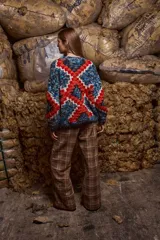 Sweater de lana multicolor con diseño geométrico en azul, rojo y blanco. Tejido y bordado a mano en Uruguay, de calce holgado con cuello a la base y puños. Talle único, similar a un M/L.