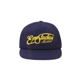 Gorra Eme Studios modelo Lister Navy, color azul marino, con visera plana y bordado frontal en amarillo con la marca y la leyenda "Madrid".