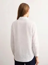 Camisa amarilla de manga larga con detalles bordados y calados en los hombros, pecho y mangas, corte clásico con cuello camisero y cierre frontal de botones.
