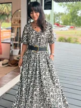 Vestido largo de corte amplio con estampado floral en tonos turquesa, blanco y rosa. Posee escote en V, mangas cortas y espalda con lazo.