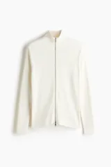 Saco de punto acanalado en mezcla de algodón y viscosa, con cuello elevado, cierre frontal bidireccional y mangas tipo martillo. Presenta un corte ajustado que define la silueta.