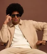 Campera masculina de estilo casual con cuello inglés, cierre frontal por cremallera, bolsillos laterales y ajuste elástico en el bajo. Presenta detalles de recortes en la parte superior delantera.