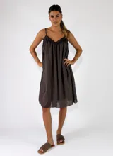 Vestido midi de tirantes color marrón oscuro, con diseño fluido, escote en V fruncido y detalles de terminación desflecada.