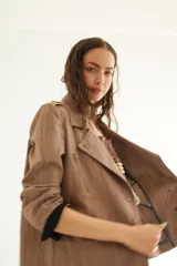 Chaqueta corta de inspiración motoquera color beige, confeccionada en lino fantasía, sin forro, con cierres decorativos, broches de presión y bolsillos delanteros funcionales. Presenta detalle bajo el cuello y en vueltas de mangas en color mostaza y rayas.