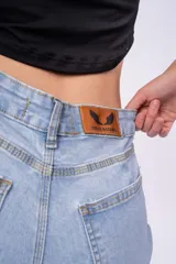 Pantalón de jean celeste de tiro alto, corte ajustado y largo hasta el tobillo.