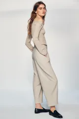 Pantalón de tiro medio con corte tipo ballon, bolsillos delanteros y detalle de pinzas. Cuenta con cierre frontal de cremallera y gancho metálico.