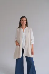 Chaleco largo abierto de tejido de punto color crudo, con bolsillos frontales aplicados y diseño sin mangas.