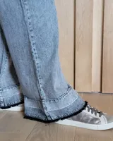 Pantalón de jean celeste de corte ancho con ruedo desflecado.