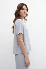 Blusa celeste de lino con cuello mao con volados, mangas cortas y cierre frontal con botones.