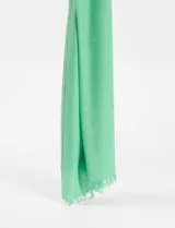 Pashmina rectangular color beige claro, de textura lisa y terminación con flecos.